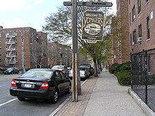 City street with a rustic, wooden Welcome to Yonkers sign