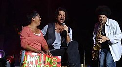 Singer, smiling woman and saxophonist on stage