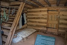 Photograph showing single bedding on a pallet on a dirt floor