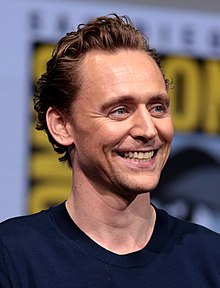 Tom Hiddleston facing to the right smiling
