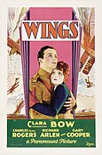 The theatrical poster of Wings. It focuses on two people. Buddy Rogers is wearing an aviator suit and Clara Bow is wearing a jacket and gloves.
