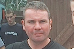 Head and shoulders of a man with greying hair.