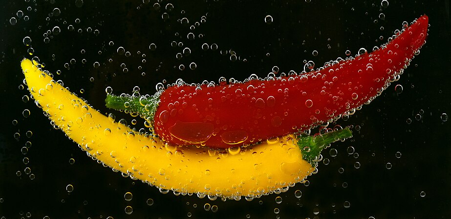 图为在水中的红色和黄色菜椒。