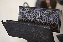 Rectangular metal plates hinged together along bottom edge; inside face of the iron is carved with lines and circular patterns