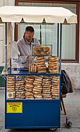一位位于波兰克拉科夫的摊贩，贩卖著盐味卷饼(波兰语被标记为 precle), 也被称作 obwarzanki krakowskie和贝果