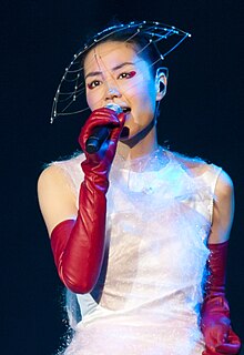 A female in white clothing is singing into a microphone