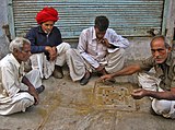 A-2. (Street game) Nav bara (9 by 12) a traditional board game in progress on the street in Manek Chowk, Ahmedabad