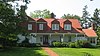 A farmhouse with white walls and a red roof