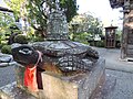 Statue of a red turtle carrying a bell on its back.