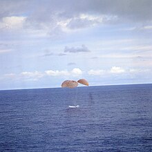 Spaceship contacts ocean under parachute