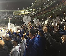 Fans participate by rising and holding signs at game 4 of the 2016 World Series