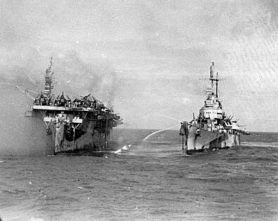 Light cruiser USS Birmingham coming alongside burning aircraft carrier USS Princeton at Battle of Leyte Gulf, 1944