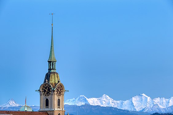 Church of the Holy Ghost in Bern. This is the spire in evening light with a clear view of the 4000m peaks of the mountains Eiger, Mönch, and Jungfrau.