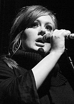 Musician Adele singing into a microphone