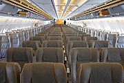 A picture of the front of the economy class cabin. Seats are lined up in a 2-4-2 arrangement across two aisles.