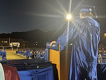 Robed student speaking at graduation