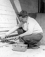 A Civilian Public Service worker distributes rat poison for typhus control in Gulfport, Mississippi, around 1945.