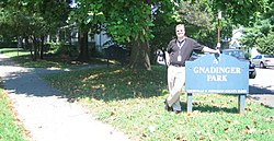 Errin Gnadinger, grandnephew of Frank and Norb Gnadinger, and grandson of Carl Gnadinger next to the Gnadinger Park sign at the intersection of Reutlinger and Ellison Avenues in Louisville, Kentucky.