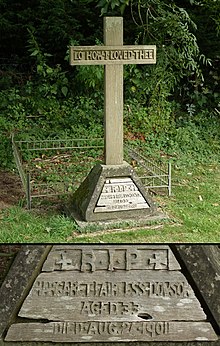 A wooden cross in the shade of a tree