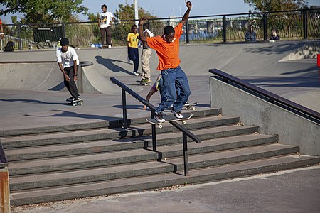 A skater boardslides in an orange shirt at Far Rockaway skatepark during the Battle of the Beach contest (2019)