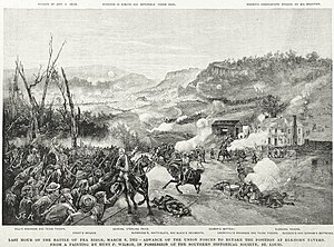 Black and white print shows a mounted man with his arm in a sling rallying soldiers during a battle. There is a two-story building at right.