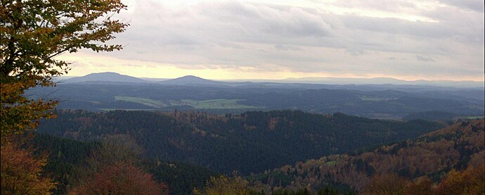 View of the Gleichberge (679 and 641 m), 24 km away. Right in the background is the High Rhön with the 928-m-high Kreuzberg 67 km away, immediately in front (centre half right) the 7-km-distant Ratscher Bergsee. In the foreground is the 621-m-high, Wachberg, 3 km away