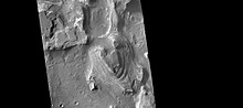 火星勘测轨道飞行器背景相机所拍摄照片显示，特比陨石坑北部有许多的岩层，在接下来的两幅图像中，该图像部分区域被放大。