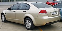 Rear-three-quarters view of a beige-coloured sedan