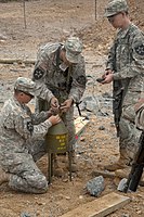 A 40 lb (18 kg) shaped charge munition (marked to indicate a Composition B filling) used for various demolition purposes such as boring a hole for a cratering charge.