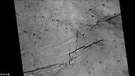 火星勘测轨道飞行器背景相机拍摄的伯纳德陨石坑部分坑底特写，显示了沟槽和尘暴痕迹。