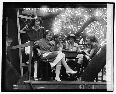 Cleon Throckmorton (middle), Kathryn Mullin (far right), Inez Hogan (top left) and others in the tree house cafe. The flappers wear the rolled stockings and low heels typical of the era's fashion.[38]