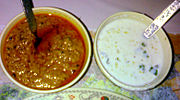 Two biryani accompaniments: mirchi ka salan and raitha/dahi chutney.
