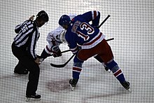 Photograph of Hayes and another player waiting for s referee to drop the puck for a faceoff