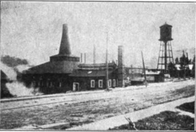 factory with smokestack and water tower