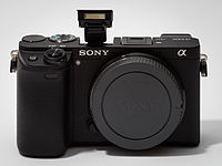 Sony Alpha ILCE-6300 APS-C-frame camera with body cap, flash extended