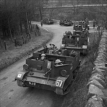 Photograph of six universal carriers driving on a road