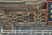 Brackets (tokyō, futatesaki in this case) under the eaves of a sanmon's roof.