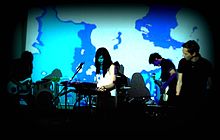 Soundpool performing under a psychedelic film backdrop.