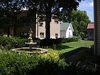 Fountain next to W.H. Morgan House (immediate right), W.H. Morgan Barn (back right with red roof), Carnegie Library (left with brown brick), Museum (back middle with green roof). Looking north-east in 2010.