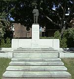 A statue of a man on a white pedestal