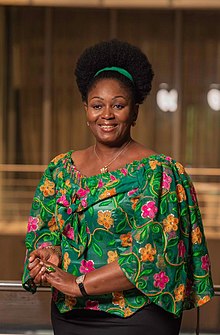 Woman in a green flowery top smiling.