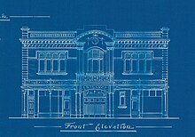 a dark blue background white line drawing of the front facade of a two story picture theatre with quite a few decorative details. Underneath the drawing in fancy printed handwriting 'Front Elevation'