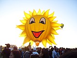 A "smiling sun" hot air balloon in front of the sun during the Philippine International Hot Air Balloon Fiesta in Pampanga, Philippines