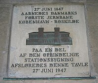 1947年在罗斯基勒站正门前设立的“哥本哈根—罗斯基勒铁路”通车百年纪念铭牌。