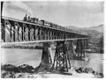 Train crossing a river on a large bridge