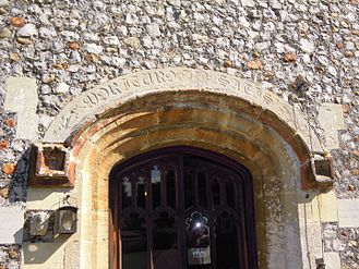 Arch with inscription over the main door, on the west facade.