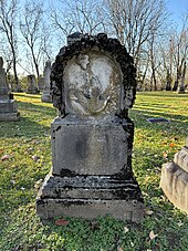 a gravestone containing a carving of a dove