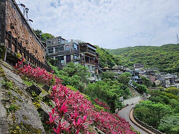 A vibrant painting of gold miners on a hillside