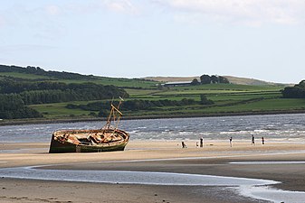 This view of Ettrick Bay beach, taken from the cafe car park, shows an abandoned and wrecked fishing boat