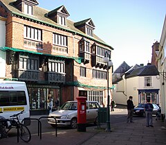 Street scene with buildings and shops. The three storey building on the left has a sign saying The Courthouse.